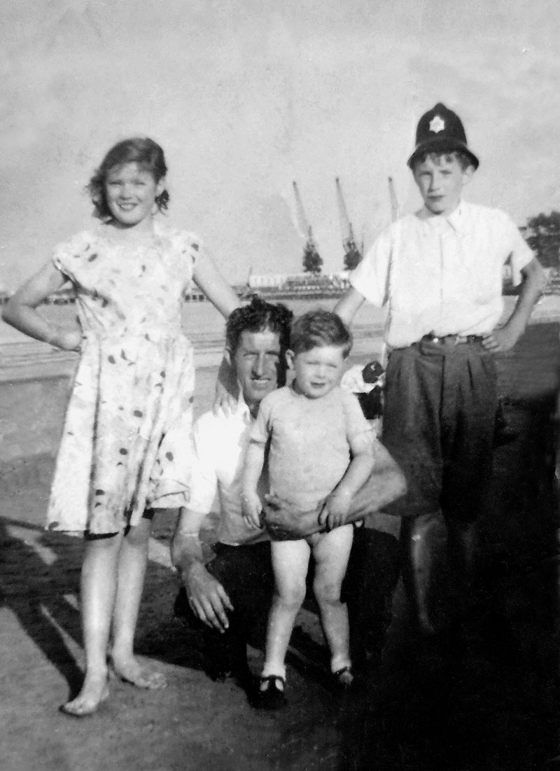 Josephine, Graham, dad, and [me], Philip Holland, at Weymouth in August, 1952.